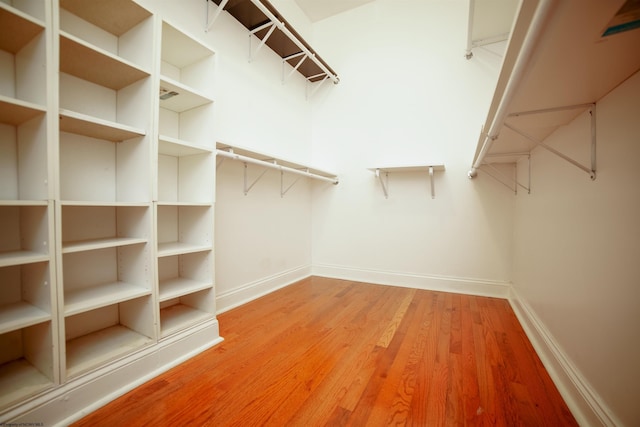 walk in closet with hardwood / wood-style floors