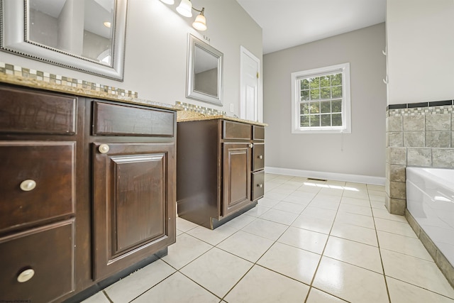 bathroom featuring tile patterned floors, a bathtub, vanity, and tile walls