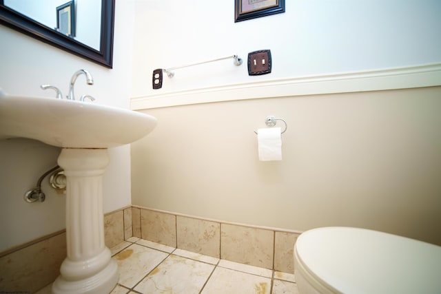 bathroom featuring toilet, tile patterned floors, and sink