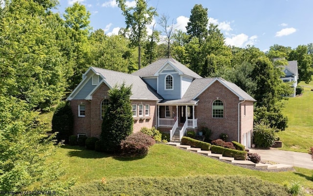 view of front of house with a front lawn, covered porch, and a garage