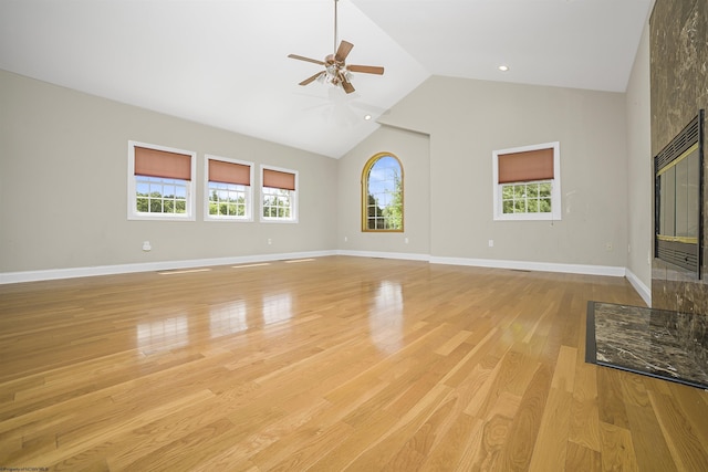 unfurnished living room with ceiling fan, a healthy amount of sunlight, light hardwood / wood-style floors, and high vaulted ceiling