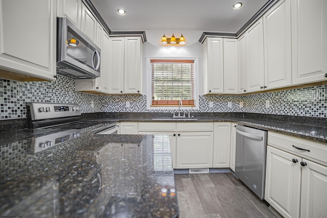 kitchen featuring dark hardwood / wood-style flooring, sink, white cabinets, and stainless steel appliances