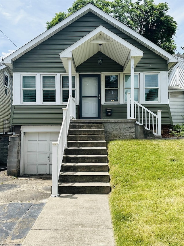 bungalow-style house featuring a garage and a front lawn