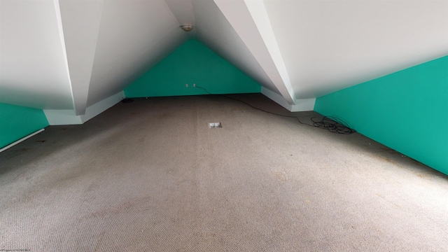 additional living space featuring lofted ceiling and carpet floors