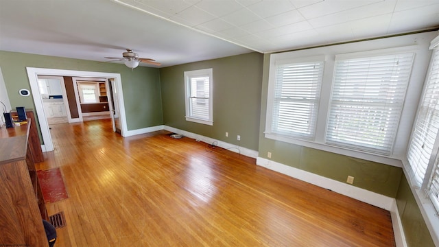 unfurnished room featuring ceiling fan, a healthy amount of sunlight, and light wood-type flooring