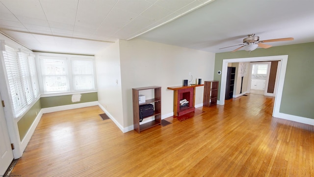 empty room with a wealth of natural light, light hardwood / wood-style flooring, and ceiling fan