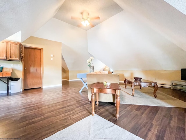 interior space featuring dark hardwood / wood-style floors, ceiling fan, lofted ceiling, and a textured ceiling