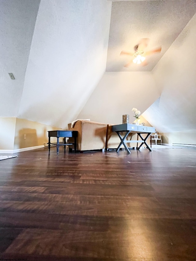 additional living space featuring vaulted ceiling, ceiling fan, dark hardwood / wood-style floors, and a textured ceiling