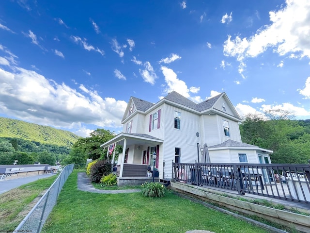 rear view of property with a porch and a lawn