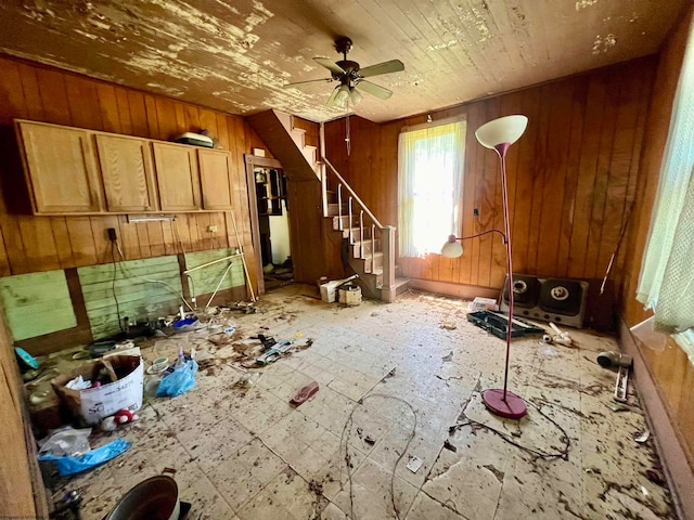 misc room with tile floors, ceiling fan, and wood walls