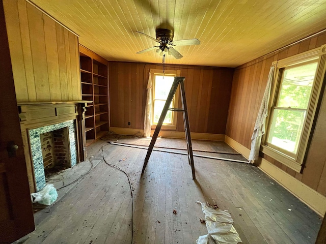 unfurnished living room with wooden walls, wooden ceiling, and wood-type flooring