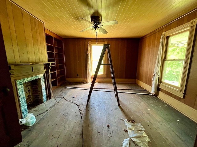 unfurnished living room with a high end fireplace, wood walls, hardwood / wood-style flooring, and wooden ceiling