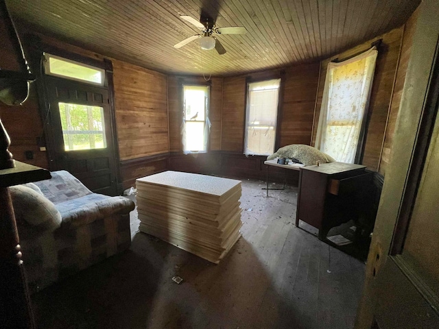 living area with a wealth of natural light, wood walls, hardwood / wood-style floors, and wooden ceiling