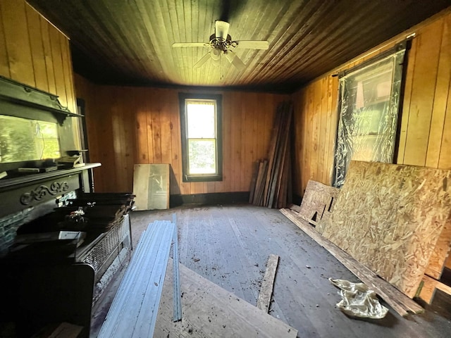 misc room featuring wood walls, ceiling fan, and wood ceiling