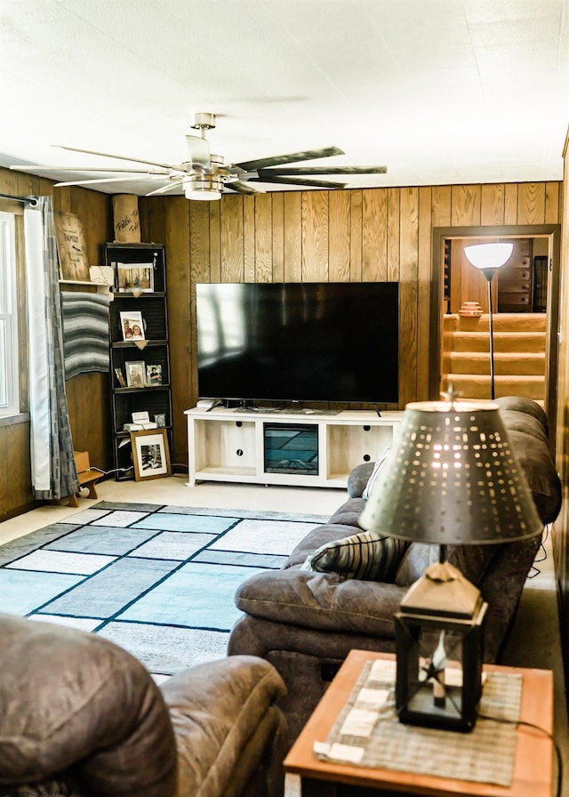 living room featuring ceiling fan and wood walls