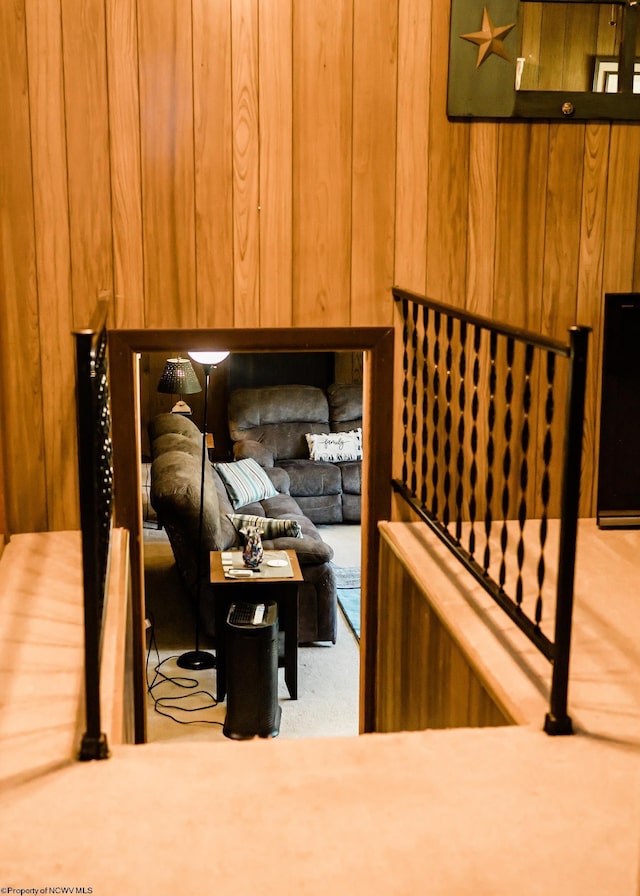 stairway featuring wooden walls and carpet