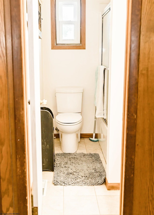 bathroom featuring shower / washtub combination, tile patterned flooring, and toilet