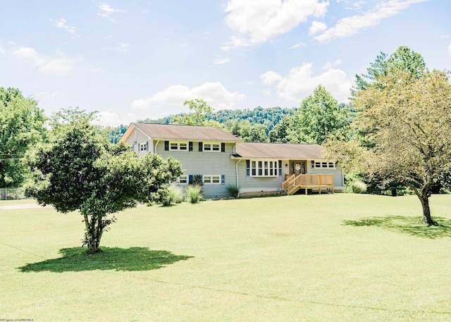 view of front of home with a front yard and a wooden deck