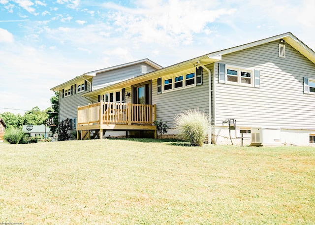 rear view of property with a wooden deck and a yard