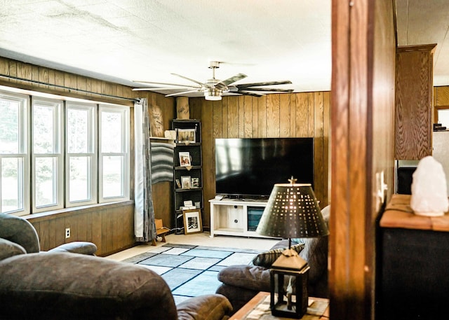 living room featuring wooden walls and ceiling fan