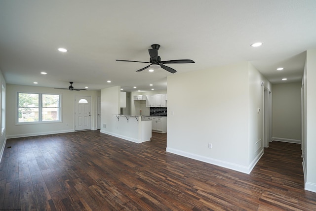 unfurnished living room featuring ceiling fan and dark hardwood / wood-style flooring