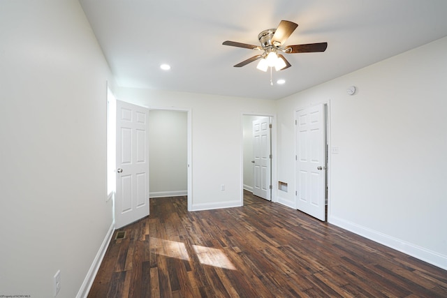 unfurnished bedroom with ceiling fan and dark wood-type flooring