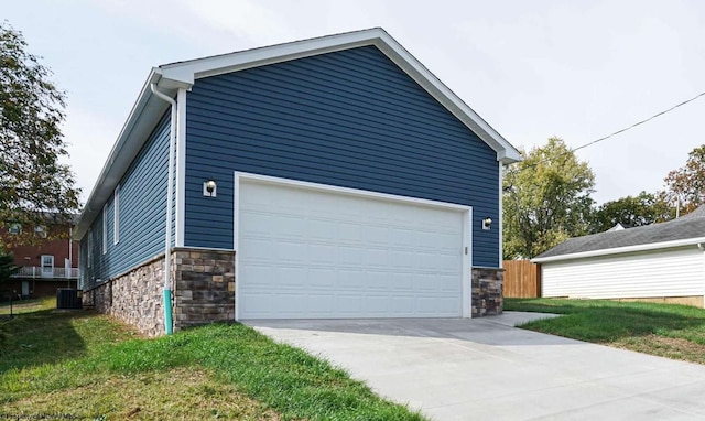 garage featuring central air condition unit and a lawn