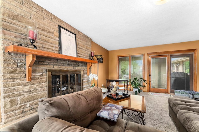 carpeted living room with a textured ceiling, a stone fireplace, and a wealth of natural light