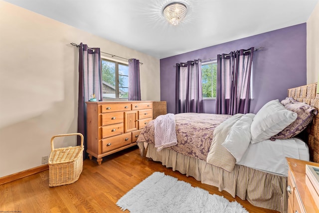 bedroom with hardwood / wood-style floors and multiple windows