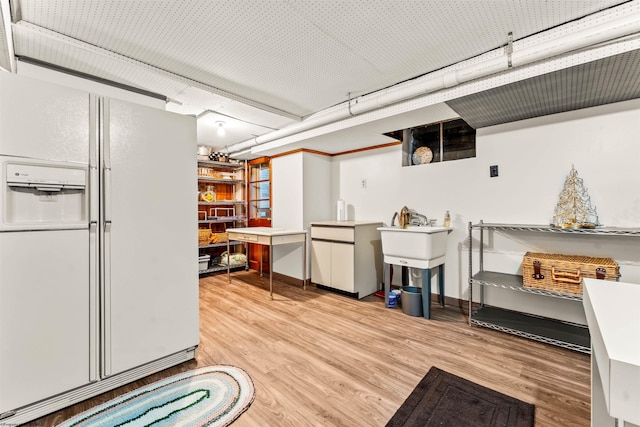 interior space featuring white refrigerator with ice dispenser and wood-type flooring