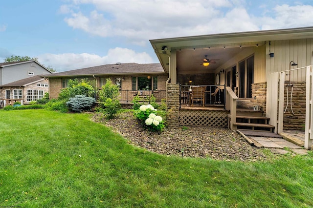 back of house featuring ceiling fan and a yard