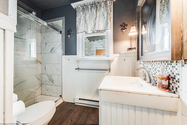 bathroom with hardwood / wood-style floors, a baseboard radiator, decorative backsplash, vanity, and a shower with door