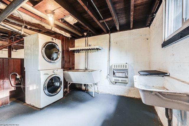 laundry room featuring heating unit, sink, and stacked washer / dryer