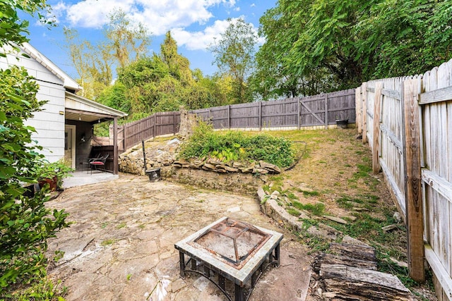 view of yard featuring a fire pit and a patio