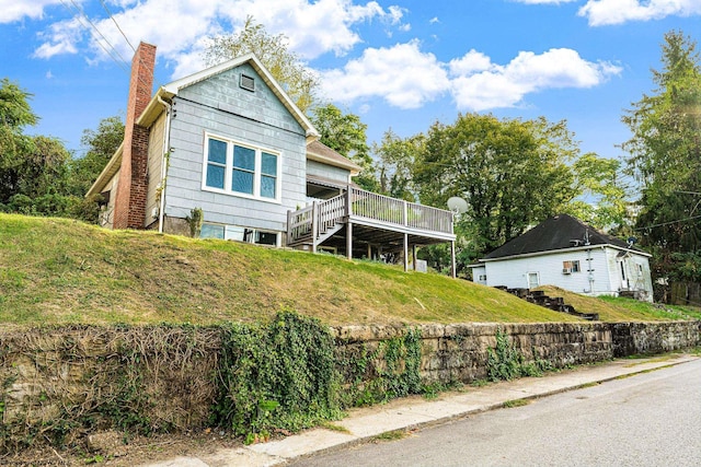 view of front of property featuring a deck and a front lawn