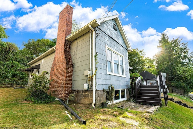 view of side of property featuring a wooden deck and a lawn