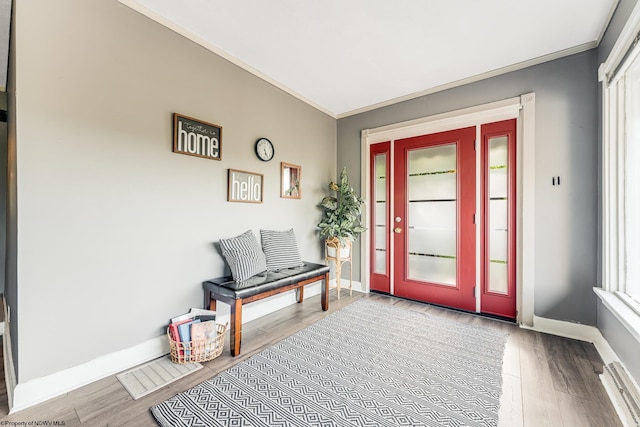 foyer with ornamental molding, plenty of natural light, and light hardwood / wood-style floors