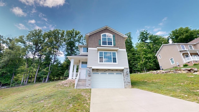 view of front of home featuring a front yard, a garage, and covered porch