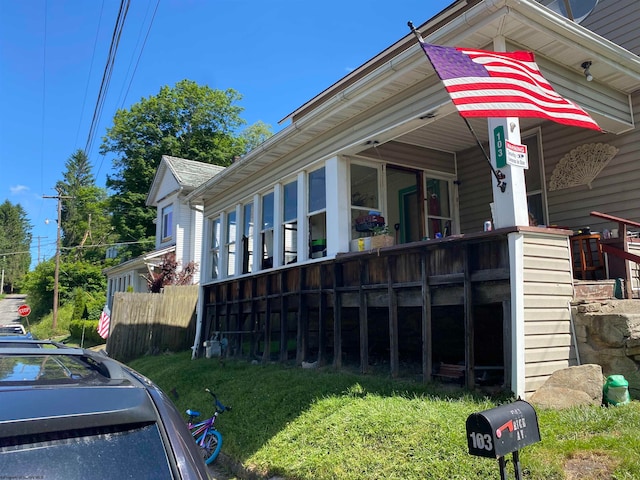 view of property exterior with a deck and a lawn