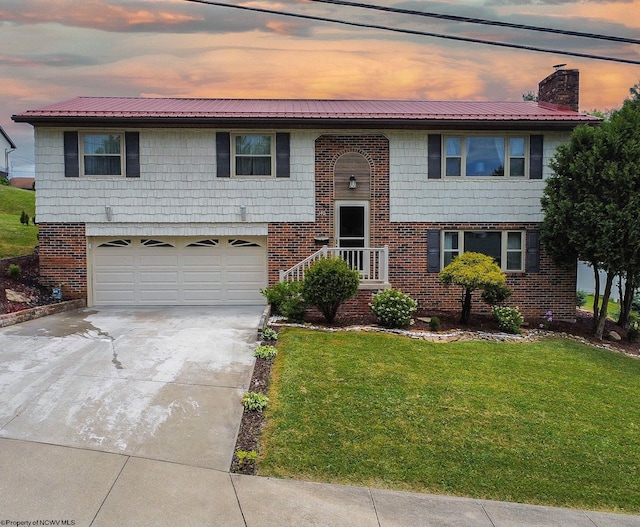 bi-level home featuring a garage and a yard