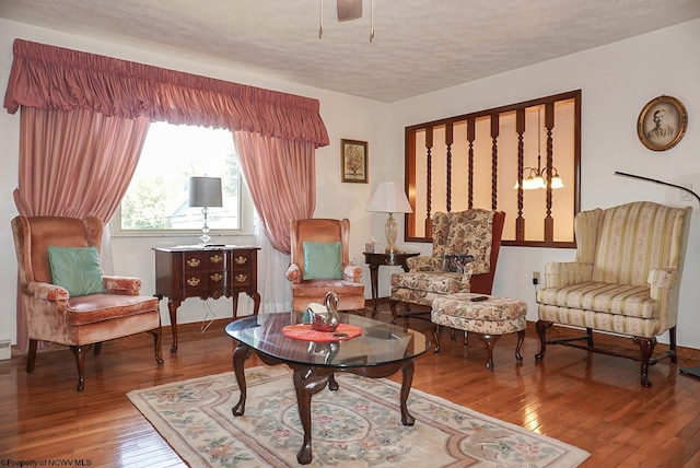 sitting room with a textured ceiling and wood-type flooring