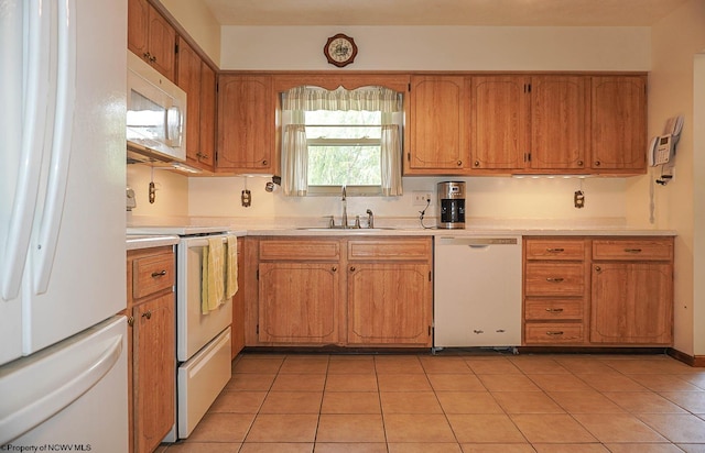 kitchen featuring white appliances, sink, and light tile floors