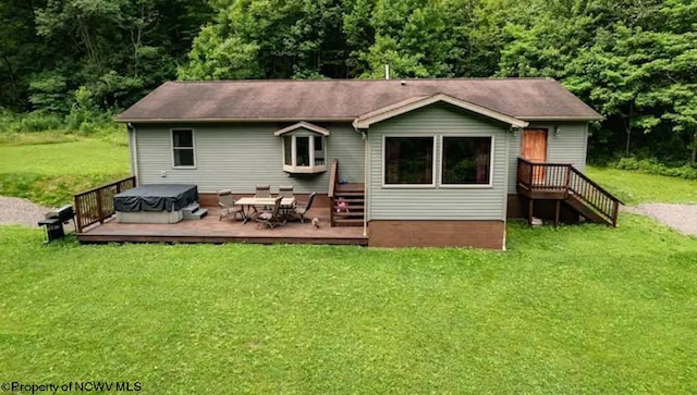 rear view of house with a wooden deck and a lawn