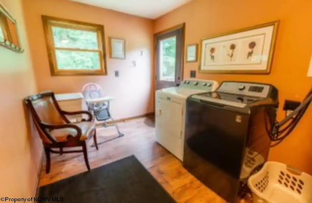 clothes washing area with light hardwood / wood-style floors and washer and dryer