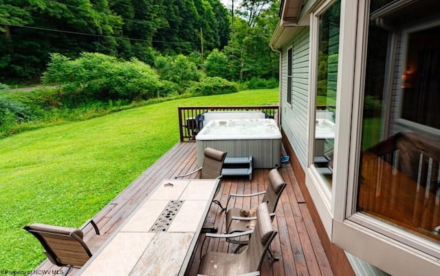 deck with a hot tub and a lawn