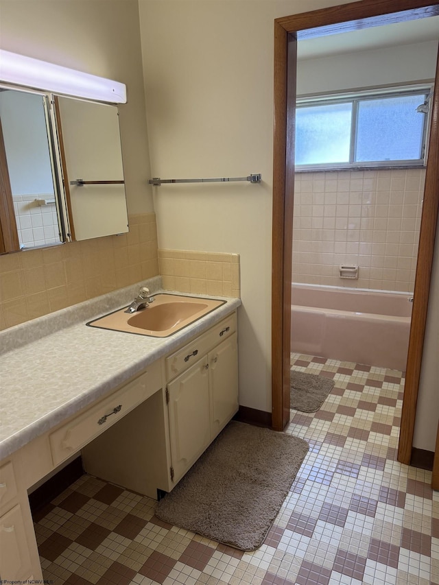 bathroom featuring decorative backsplash, vanity, and a bathtub