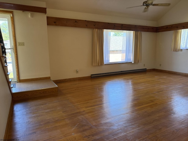 spare room with hardwood / wood-style floors, vaulted ceiling, ceiling fan, and a baseboard heating unit