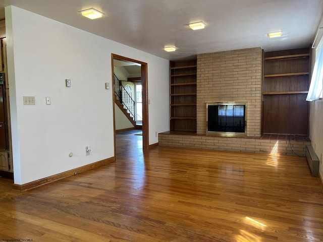 unfurnished living room featuring dark wood-type flooring and a brick fireplace