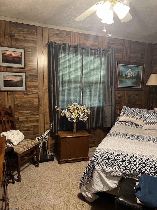 bedroom with carpet floors, wood walls, ceiling fan, and a textured ceiling