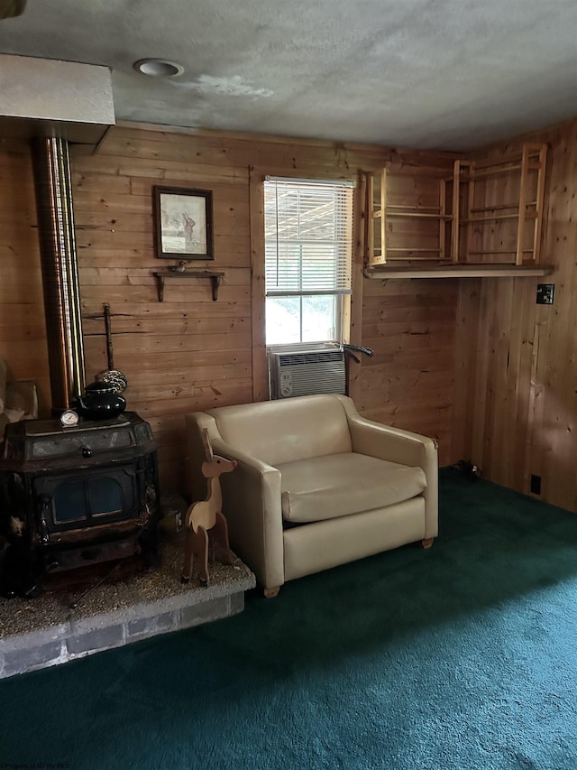 living area with cooling unit, a wood stove, wood walls, and carpet flooring